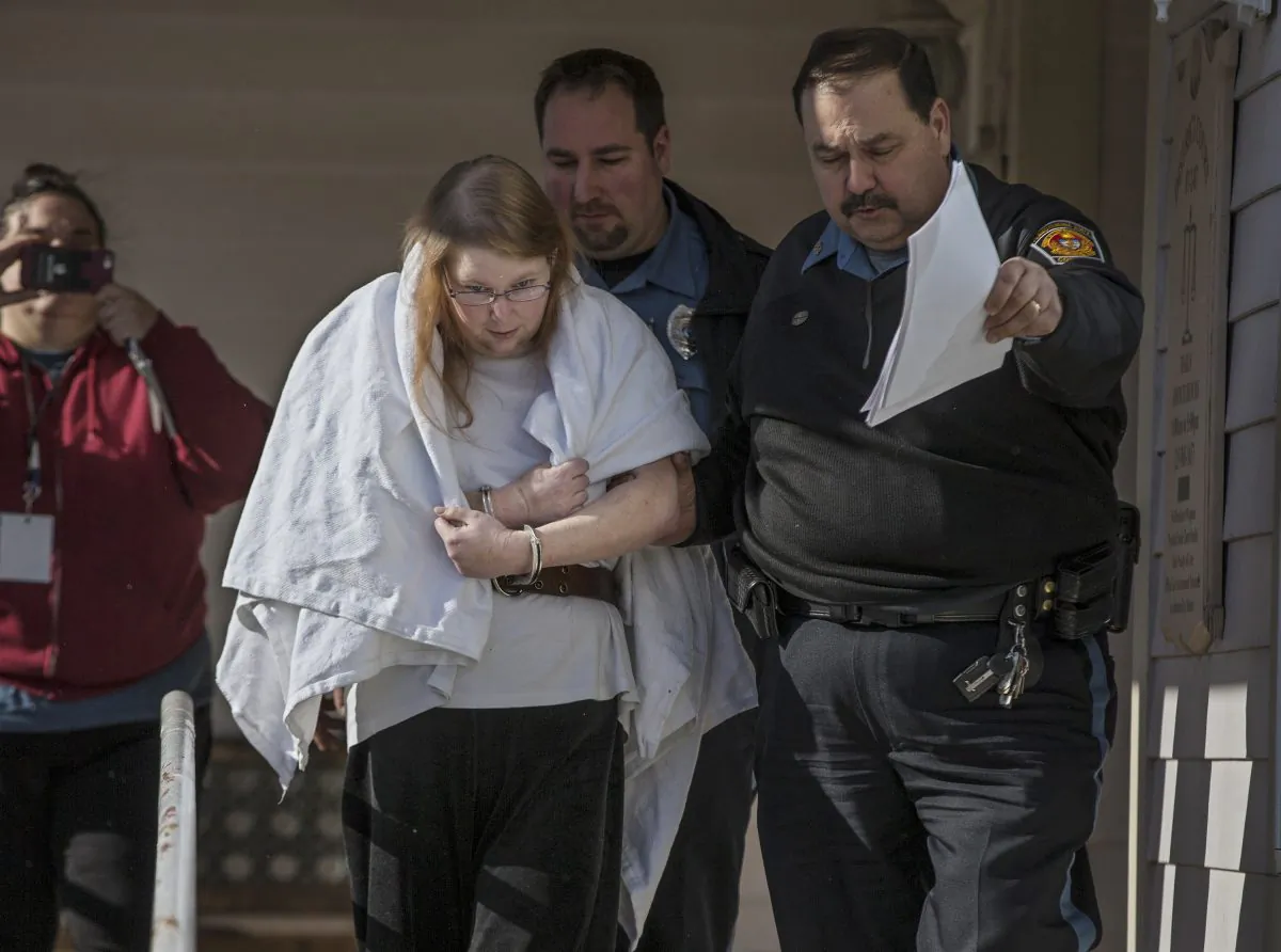 FILE - In this Jan. 8, 2017 file photo, Sara Packer, center, handcuffed, the adoptive mother of Grace Packer, is led out of District Court in Newtown, Pa.,  by Pennsylvania Constables and taken into custody. Packer, whose teenage daughter's dismembered remains were found in the woods last fall, has been charged along with her boyfriend Jacob Sullivan with killing the girl in a "rape-murder fantasy" the couple shared, a prosecutor said. (Michael Bryant/The Philadelphia Inquirer via AP, File)