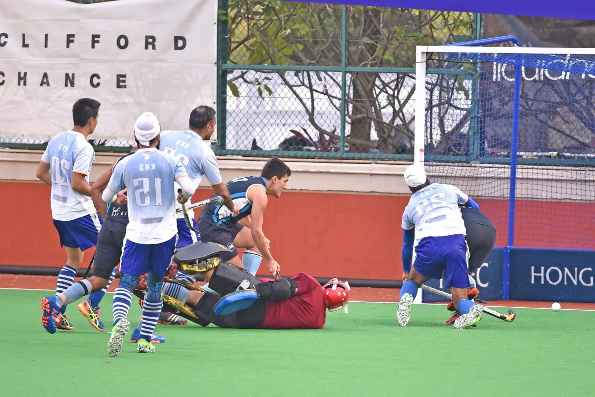 HKFC-A player Angus Allen (obscured) behind KNS-A’s No 29 Harmanpreet Singh converts this goal from a partial block of an Istiaq Ahmed shot by the KNS goalie to regain the lead at 2-1 in their HKHA Premier Group A league at HKFC on Sunday Jan 22. The final score was 3-1 to HKFC. (Bill Cox/Epoch Times).