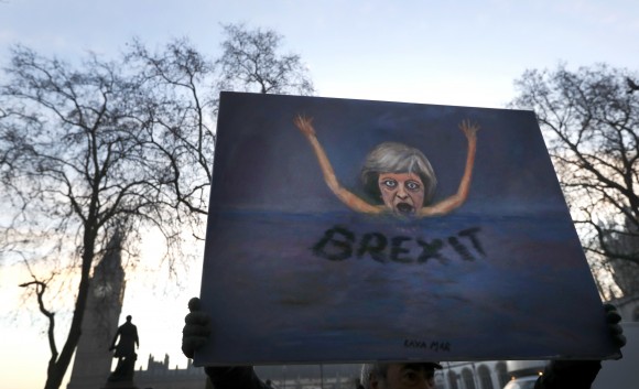 Artist Kaya Mar holds a painting near Parliament in London, Tuesday, Jan. 24, 2017. Lead plaintiff Gina Miller says British Supreme Court ruling provides the legal foundation to trigger Brexit. (AP Photo/Kirsty Wigglesworth)
