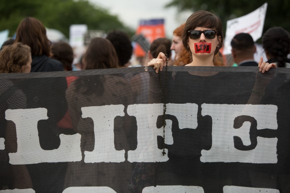 A pro-life protester holds a sign in front of the U.S. Supreme Court on a day where two important decisions on immigration and affirmative action were handed down by the court in Washington, DC, on June 23, 2016. (Allison Shelley/Getty Images)