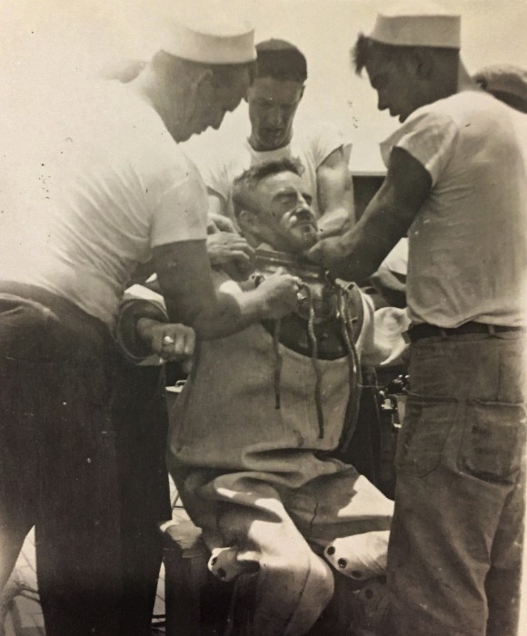 This circa 1943 photo provided by the Hartle family shows Navy diver Ken Hartle getting into his dive suit in Pearl Harbor, Hawaii. (Courtesy Hartle Family via AP)