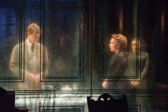 Tim Hatley's masterful set, with its transparent walls, permits the audience to see the actions of the past repeated—such as Oswald accosting the maid, just as Oswald's father had accosted the prior maid. These ghosts of the past haunt the present in a literal way. (Stephanie Berger)