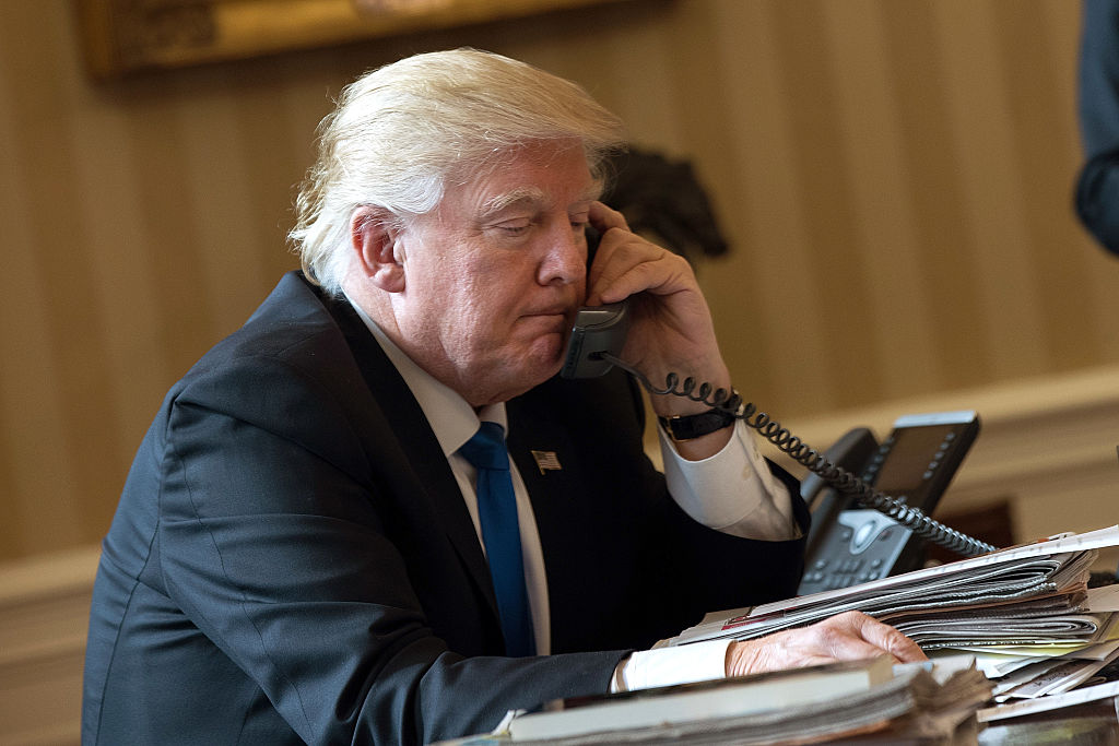 President Donald Trump speaks on the phone with Russian President Vladimir Putin in the Oval Office of the White House, in Washington, DC. on Jan.28, 2017. (Photo by Drew Angerer/Getty Images)