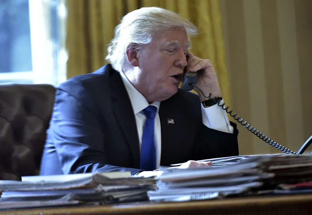 US President Donald Trump speaks on the phone with Russia's President Vladimir Putin from the Oval Office of the White House on January 28, 2017, in Washington, DC.  / AFP / MANDEL NGAN        (Photo credit should read MANDEL NGAN/AFP/Getty Images)
