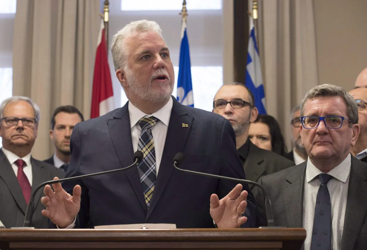 Quebec Premier Philippe Couillard speaks to reporters as Quebec City Mayor Regis Labeaume looks on at a news conference in Quebec City on Jan. 30, 2017. (The Canadian Press/Jacques Boissinot)