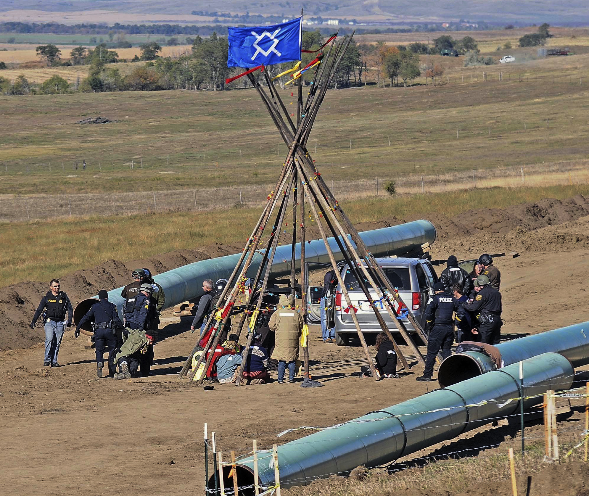 Law enforcement officers (L) drag a person from a protest against the Dakota Access Pipeline, near the town of St. Anthony in rural Morton County, N.D., on Oct. 10, 2016. (Tom Stromme/The Bismarck Tribune via AP)