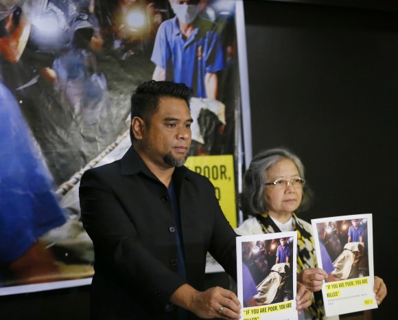 Amnesty International campaigner Wilnor Papa, left, and Board of Trustee Sis. Maria Vida Cordero hold copies of the Amnesty's repport on extra-judicial killings in the country following a video news conference with their London counterpart Rachel Chhoa-Howard, in suburban Quezon city, northeast of Manila, Philippines Wednesday, Feb. 1, 2017. A majority of the thousands of killings of poor suspects under Philippine President Rodrigo Duterte's anti-drug crackdown appear to be "extrajudicial executions," Amnesty International said Wednesday, and may constitute crimes against humanity. (AP Photo/Bullit Marquez)