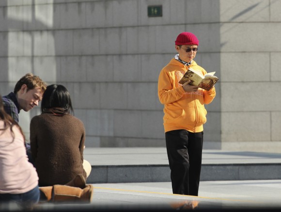 In this Dec. 2013, photo, Xiao Jianhua, a Chinese-born Canadian billionaire, reads a book outside the International Finance Centre in Hong Kong. Mystery surrounds the whereabouts of Xiao reportedly taken away from his Hong Kong hotel by mainland police, in a case that could rekindle concerns about overreach by Chinese law enforcement in the semiautonomous city. (AP Photo/Next Magazine)