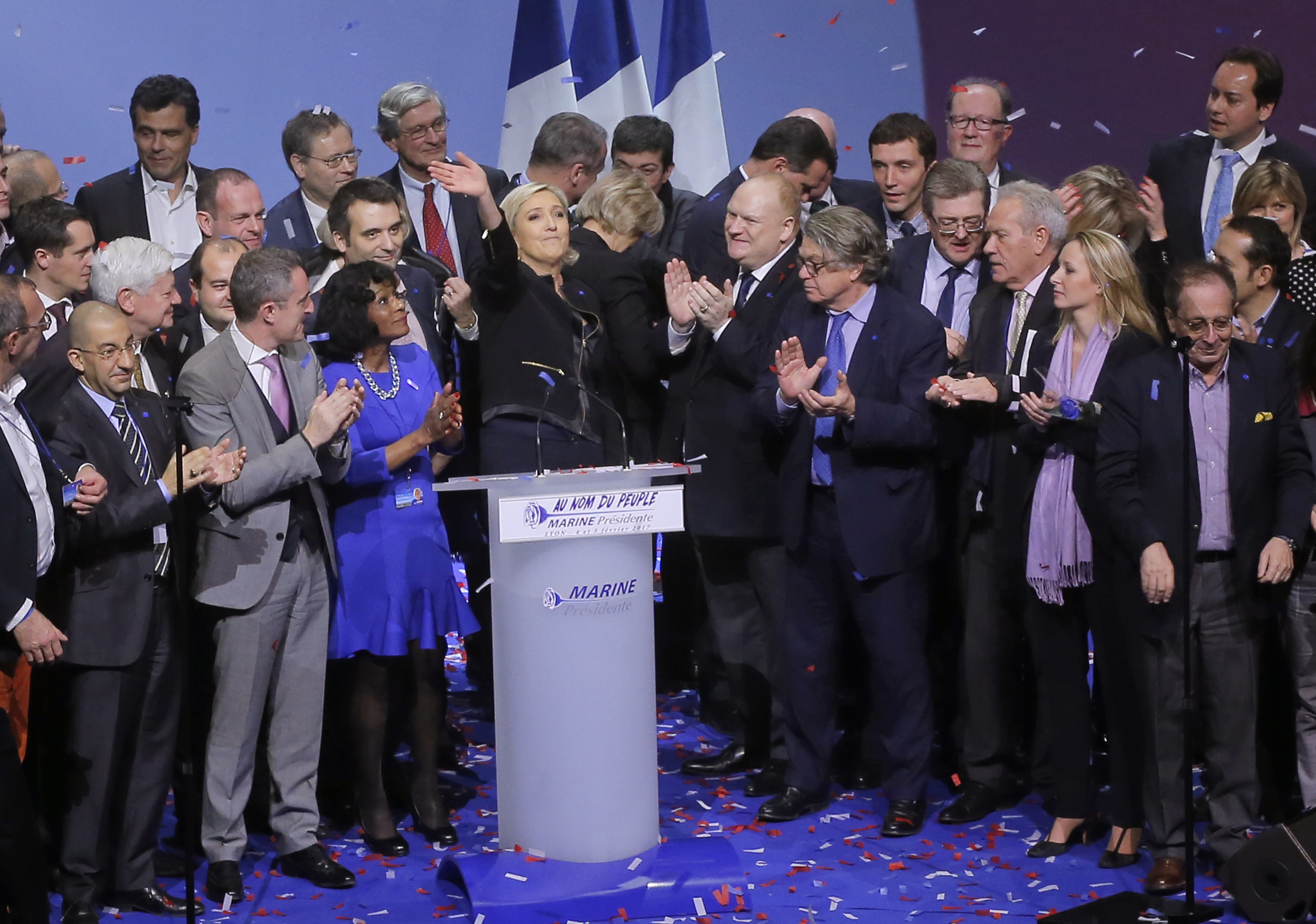 Far-right leader presidential candidate Marine Le Pen waves to supporters as she stands among her party officials at the end of a conference in Lyon, France on Feb. 5, 2017. (AP Photo/Michel Euler)