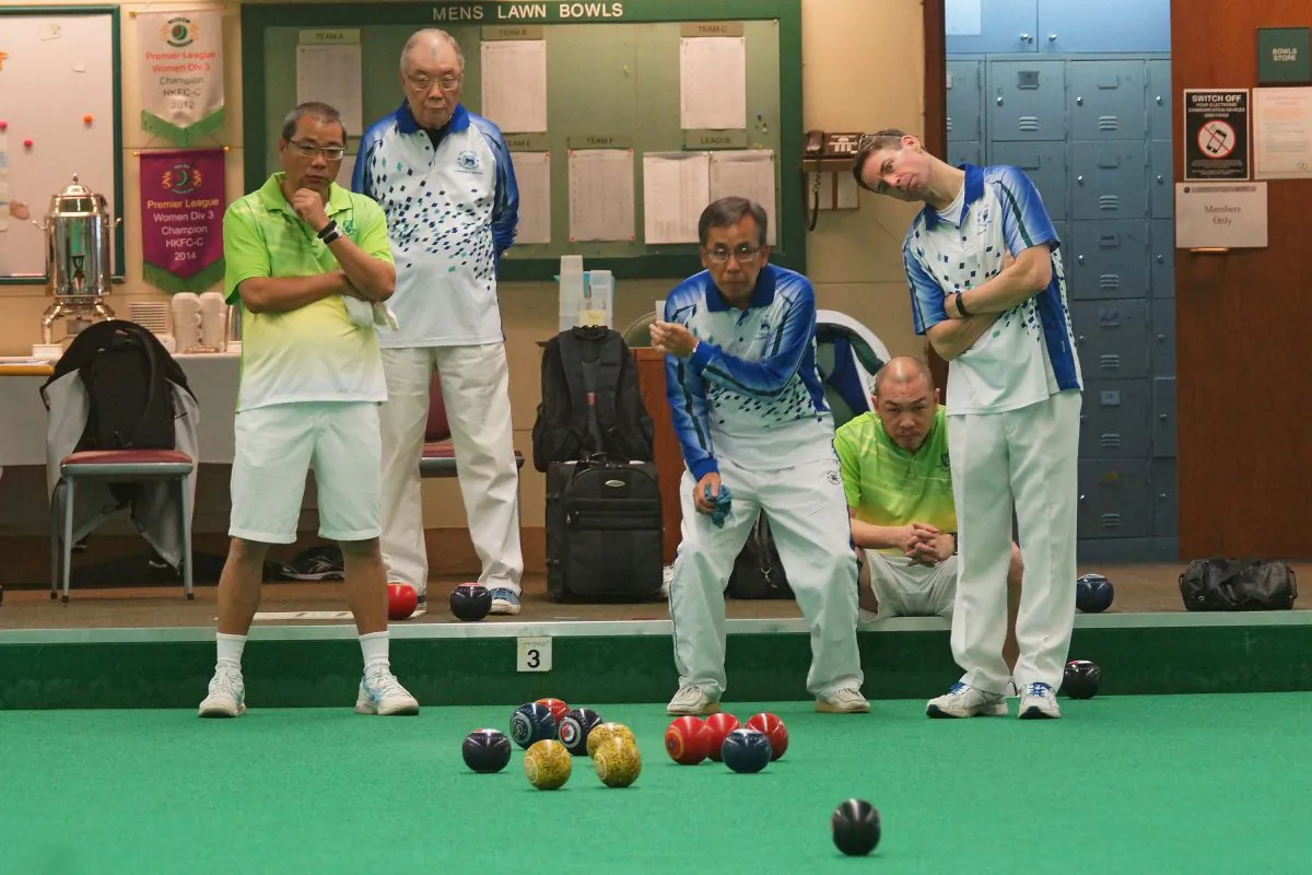 Hong Kong Football Club skipper Neil Herrington (right) tried to get a better view on a bowl delivered by his opposing skip Li Ming Sum (not in photo). Herrington finally won the game 23-16. (Mike Worth)
