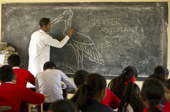 In this Feb. 6, 2017, photo, a teacher of Sankardev Sishu Niketan school draws a Greater Adjutant Stork, an endangered bird with a total population of 1,200 in the world, on a blackboard at Dadara village, west of Gauhati, India. With about 800 birds Assam has the largest number of the Greater Adjutant Stork, concentrated largely in three villages just northwest of state capital Gauhati. Conservationists say they have launched a pride campaign among the children and youth so they can proudly say their village is home to the hargilas, the name of the bird in local Assamese language. (AP Photo/Anupam Nath)