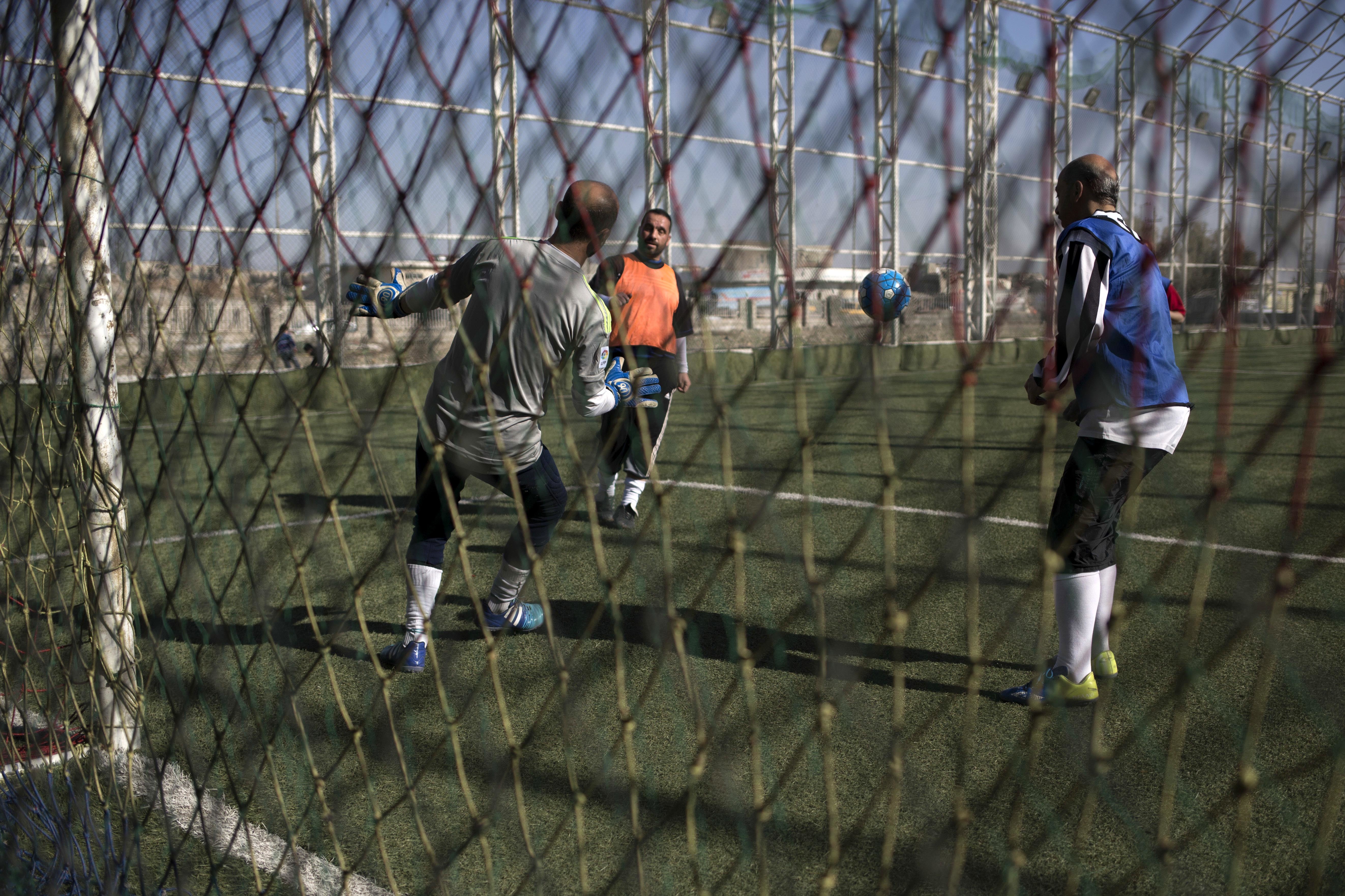 Mosul residents play soccer on a pitch in the liberated eastern part of the city on Feb. 8, 2017. (AP Photo/Bram Janssen)