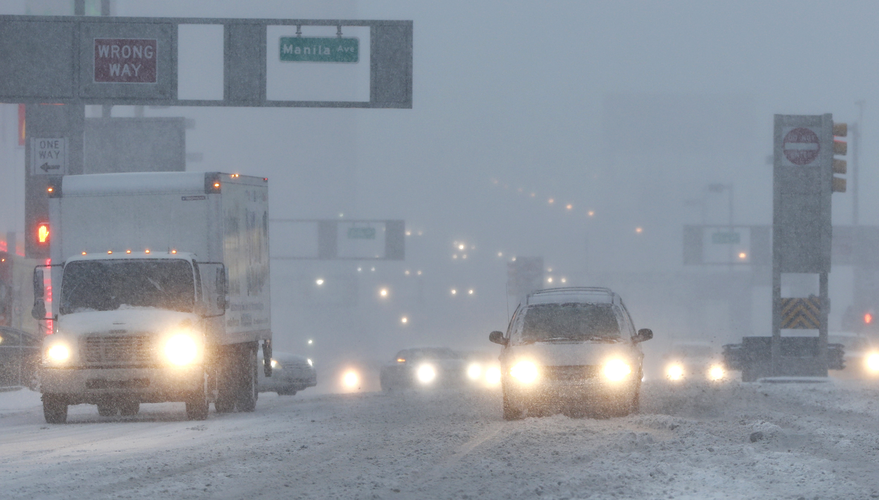 Vehicles drive drive through snow as they approach the Holland Tunnel in Jersey City, N.J., on Feb. 9, 2017. (AP Photo/Julio Cortez)