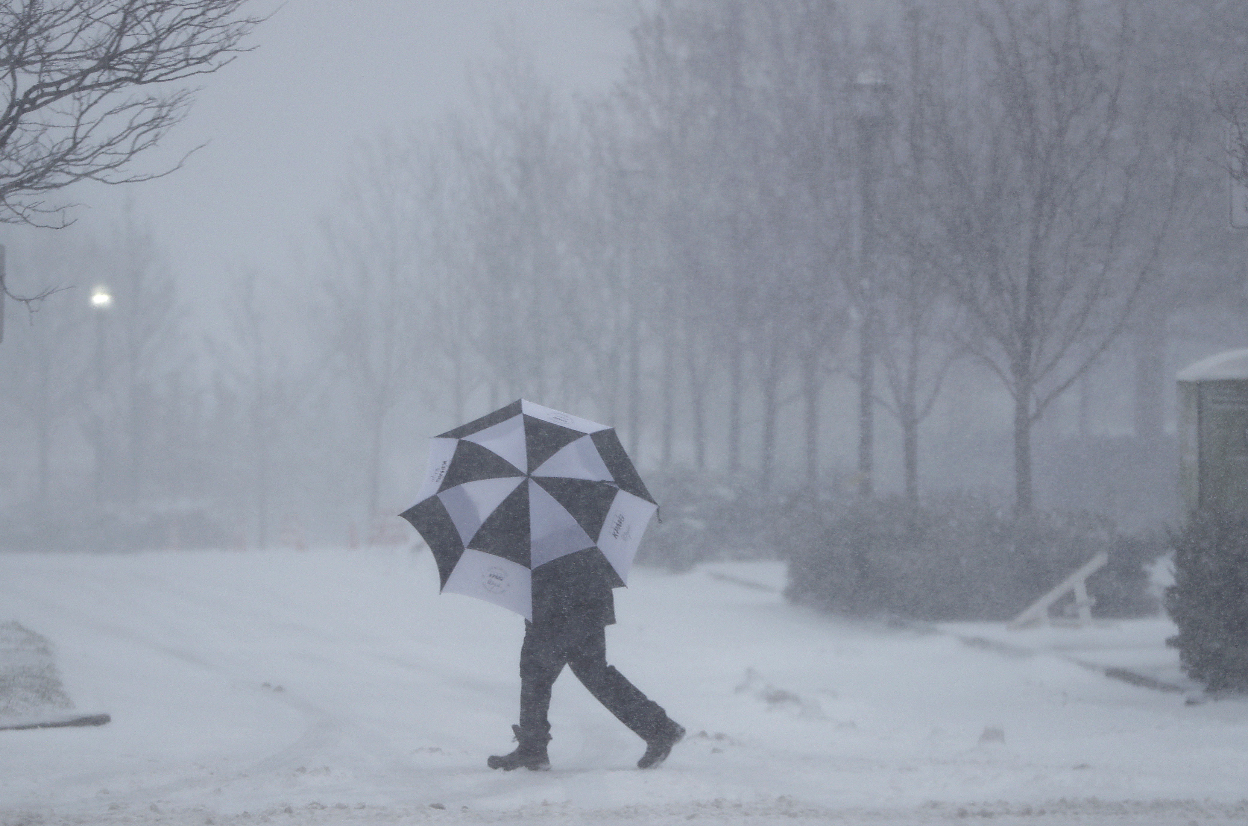 A person shields itself from falling snow with an umbrella in Jersey City, N.J., on Feb. 9, 2017. (AP Photo/Mark Lennihan)