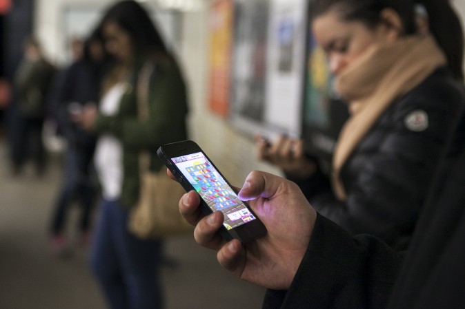 People play candy crush in the subway in New York, April 1, 2014. (Samira Bouaou/Epoch Times)