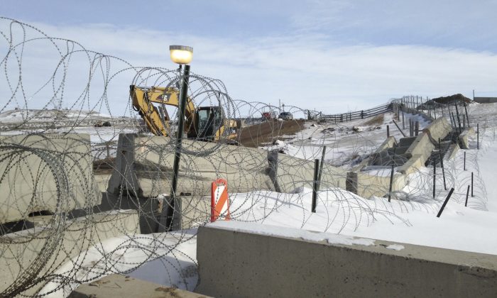 Razor wire and concrete barriers protect access to the Dakota Access pipeline drilling site Thursday, Feb. 9, 2017 near Cannon Ball, North Dakota. The developer says construction of the Dakota Access pipeline under a North Dakota reservoir has begun and that the full pipeline should be operational within three months. One of two tribes who say the pipeline threatens their water supply on Thursday filed a legal challenge asking a court to block construction while an earlier lawsuit against the pipeline proceeds. (AP Photo/James MacPherson)