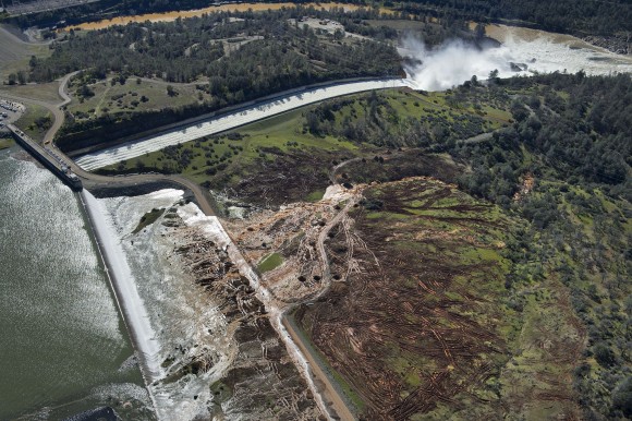Lake water flows over the emergency spillway, bottom left, at Lake Oroville for the first time in the nearly 50-year history of the Oroville Dam in Oroville, Calif., on Feb. 11, 2017. (Randy Pench/The Sacramento Bee via AP)