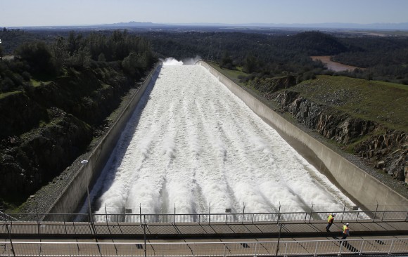 In this Saturday, Feb. 11, 2017, photo, water flows down Oroville Dam's main spillway, in Oroville, Calif. Officials have ordered residents near the Oroville Dam in Northern California to evacuate the area Sunday, Feb. 12, saying a "hazardous situation is developing" after an emergency spillway severely eroded. (AP Photo/Rich Pedroncelli)