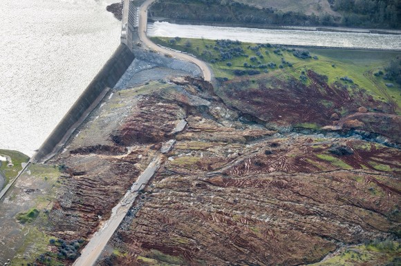 In an aerial photo, the emergency spillway at Lake Oroville shows signs of damage from the water which spilled over recently in Oroville, Calif. on Feb. 13, 2017. The water level dropped Monday behind the nation's tallest dam, reducing the risk of a catastrophic spillway collapse and easing fears that prompted the evacuation of nearly 200,000 people downstream. (Randy Pench/The Sacramento Bee via AP)