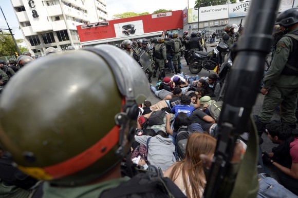 National Guard personnel in riot gear arrest students during an anti-government demonstrators in Caracas on May 14, 2014. About 80 demonstrators were arrested during a protest as they request the immediate release of youth detained in recent days. (JUAN BARRETO/AFP/Getty Images)