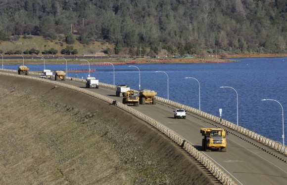 Truck after truck line the Oroville Dam roadway as the effort to stabilize the emergency spillway continues Tuesday, Feb. 14, 2017, in Oroville, Calif. Officials say the decision to lift the evacuation order for nearly 200,000 people living below a damaged dam in California has taken into account updated weather forecasts. A storm later this week is expected to be colder, with less rain. (Michael Macor/San Francisco Chronicle via AP)