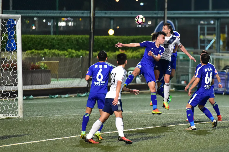Gary Gheczy (HKFC white no 22), scorer of 2 headers directs his first goalwards in R&F penalty box, watched by colleague Tom Smith (white 27) but the fightback fell short with 4-3 defeat by R&F. (Bill Cox/Epoch Times)

