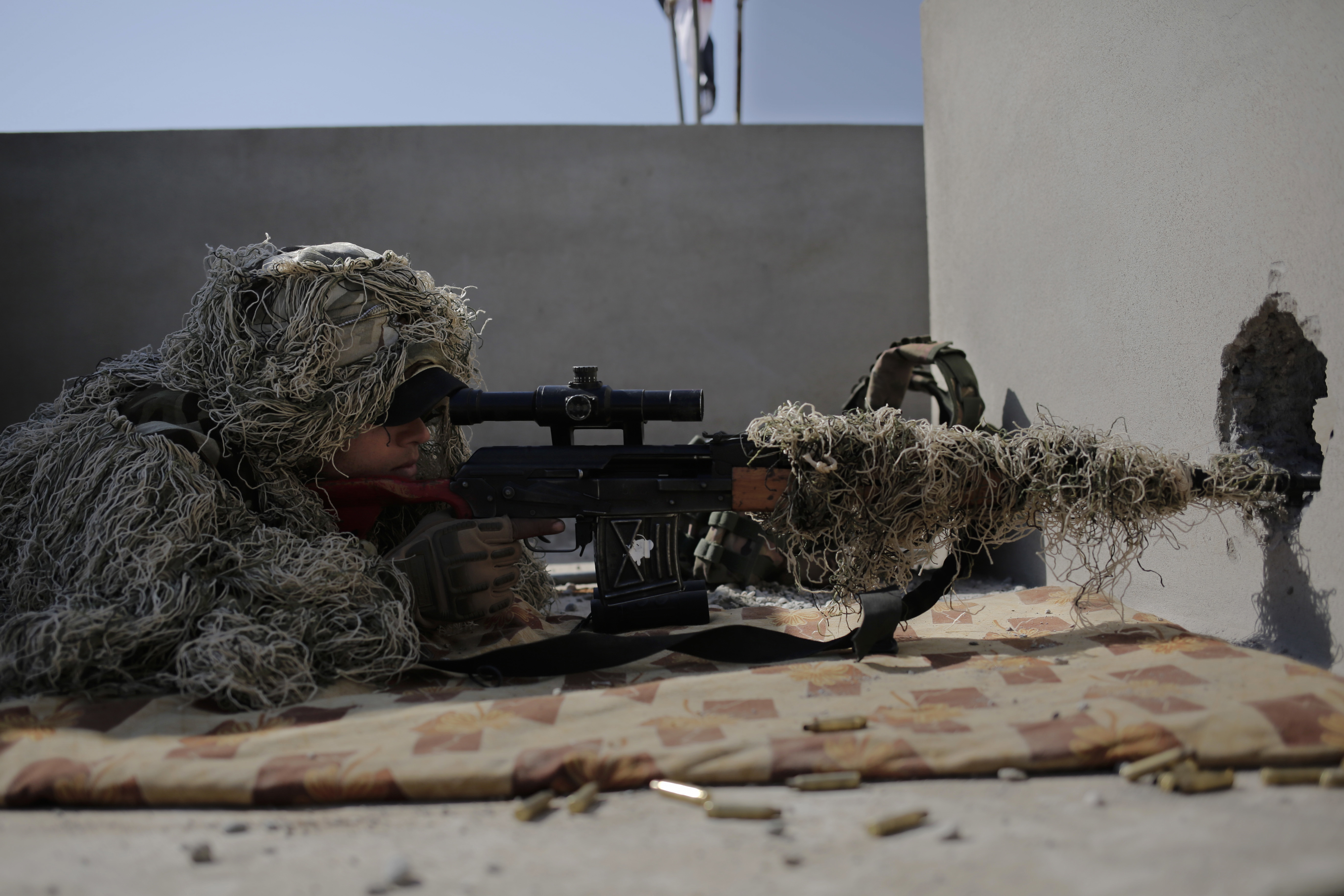 A sniper with the Iraqi federal police aims at an ISIS position from the rooftop of a house in the town of Abu Saif, on Feb. 22, 2017. (AP Photo/Bram Janssen)