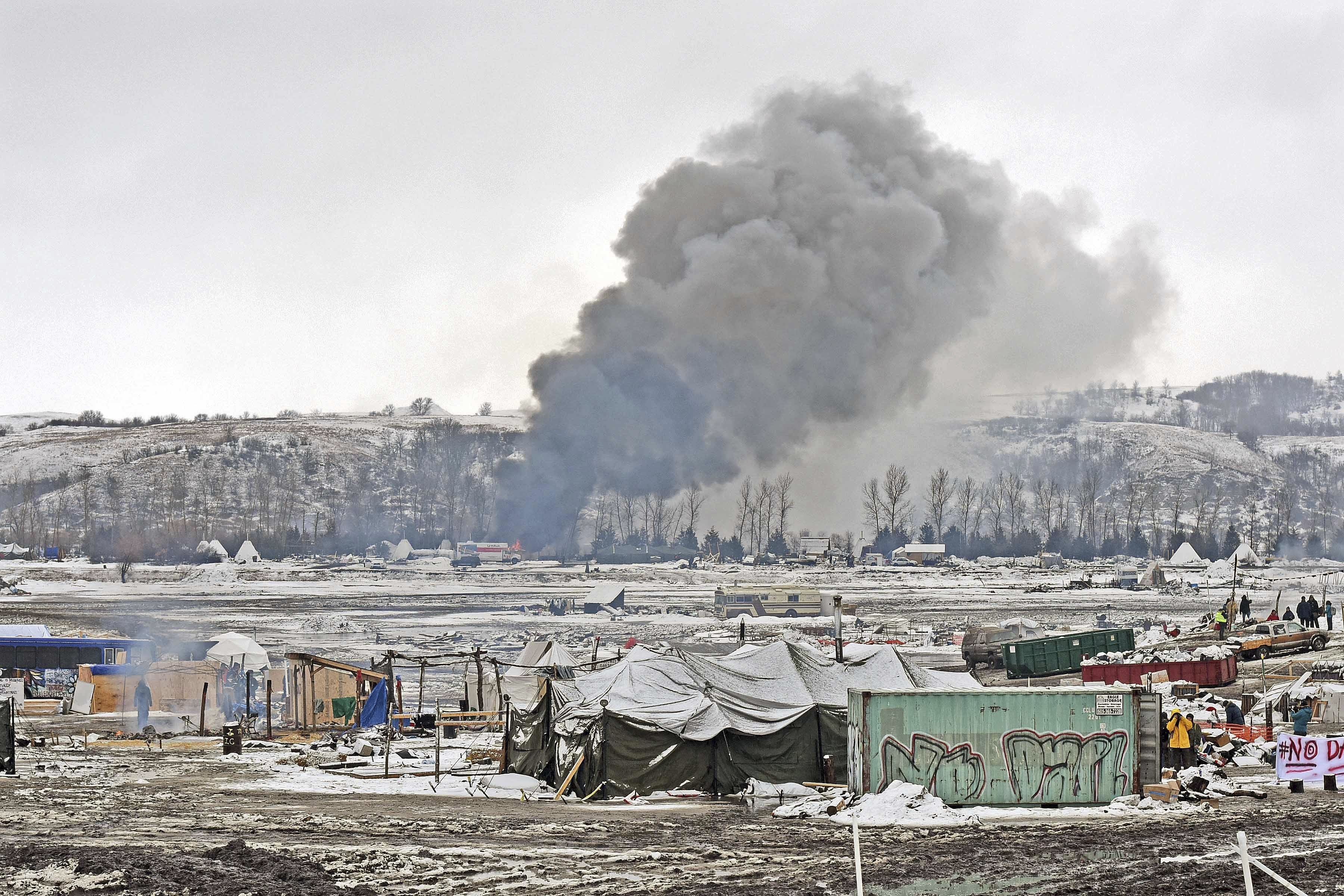 Smoke from fires set by protesters goes up as they leave their protest camp on U.S. Army Corps of Engineers property in southern Morton County, near Cannon Ball, N.D., on Feb. 22, 2017. (Tom Stromme/The Bismarck Tribune via AP)