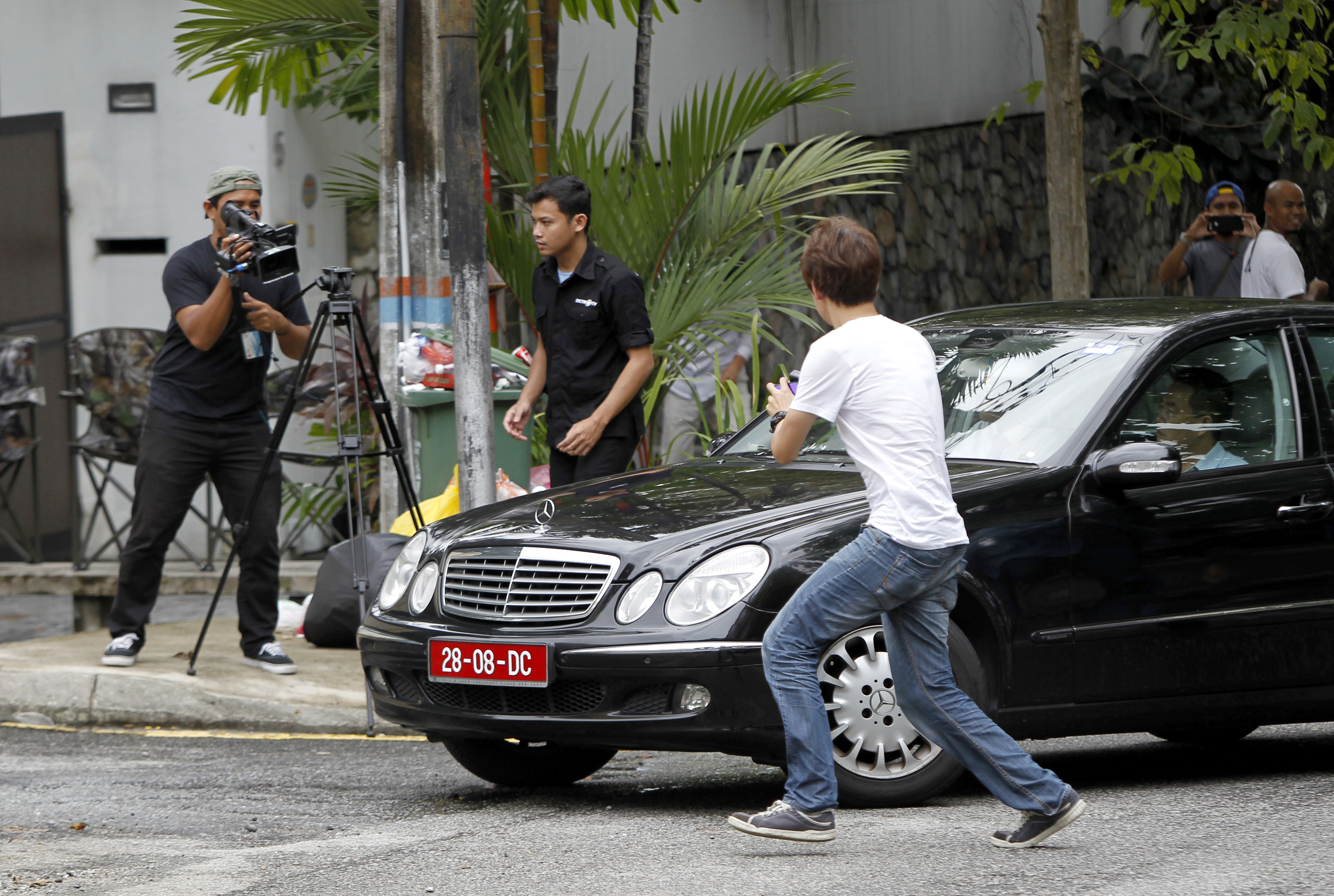 Journalists chase a car leaving North Korean Embassy in Kuala Lumpur, Malaysia on Feb. 27, 2017. (AP Photo/Daniel Chan)