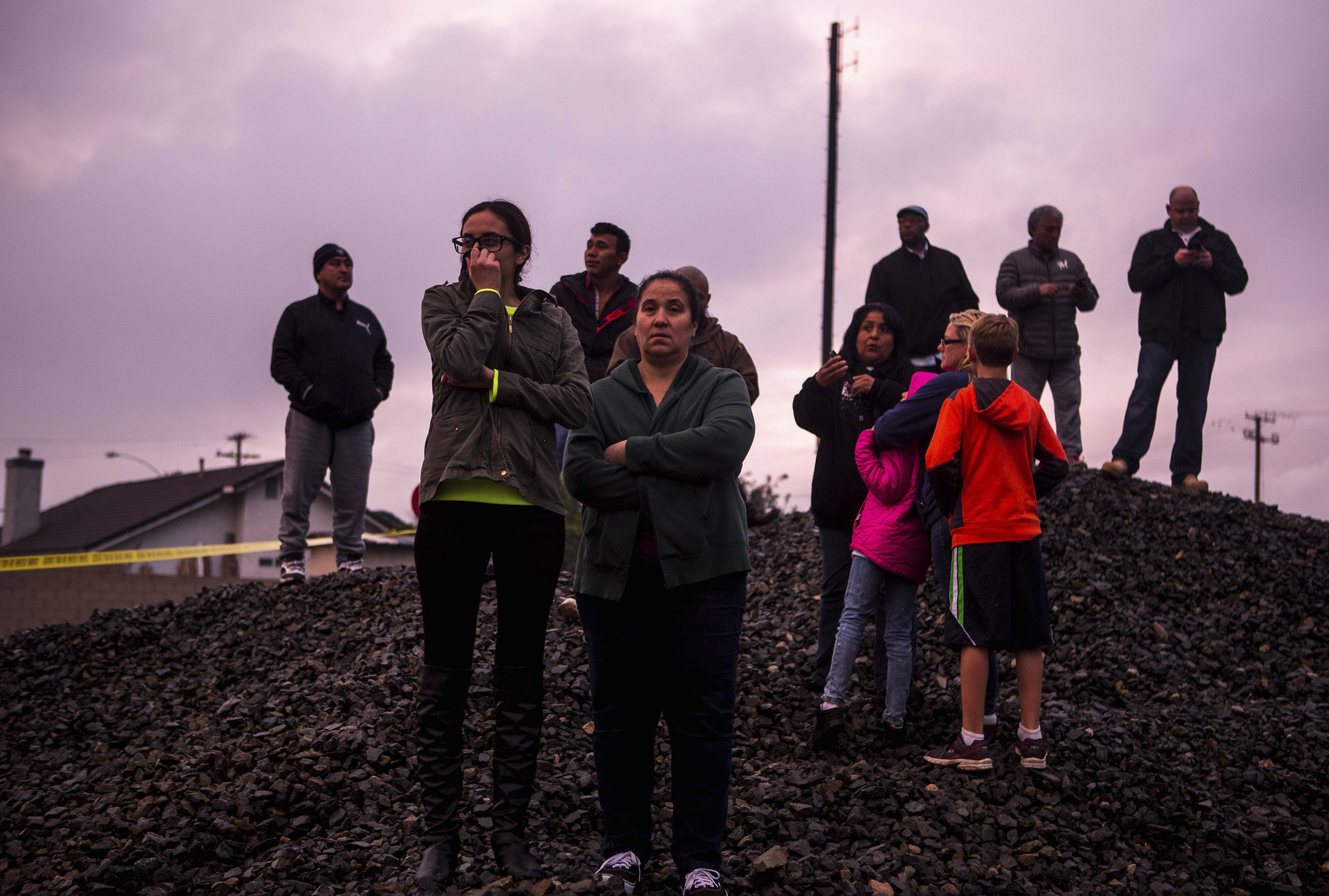 Residents watch as smoke rises from a fire after a plane crashed in Riverside, CA., on Feb. 27, 2017. (Watchara Phomicinda/The Press-Enterprise via AP)