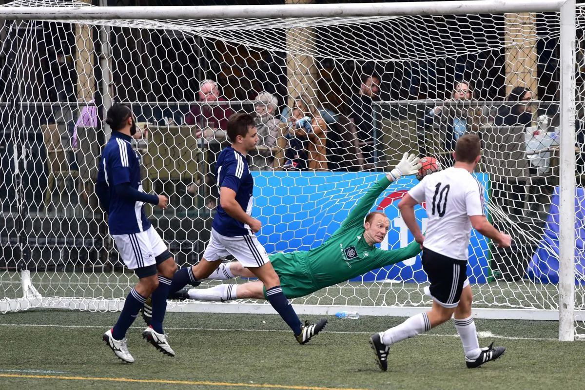 Adam Wise of GAS equalizes past Wanderers’ Freddy Toomer late in normal time to take the game into 2 10-minute periods of Extra Time in the Yau Yee League Cup Quarter Final match at Sports Road on Sunday Feb 26. Wanders went on to win a close match 2-1. (Bill Cox/Epoch Times)