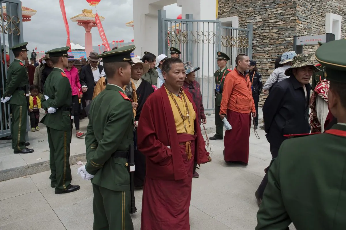 Chinese paramilitary police (in green uniforms) secure an exit as Tibetans monks (C) walk out from a stadium at the end of a local government sponsored festival in the northwestern Chinese province of Qinghai in this file photo. (Nicolas Asfouri/AFP/Getty Images)