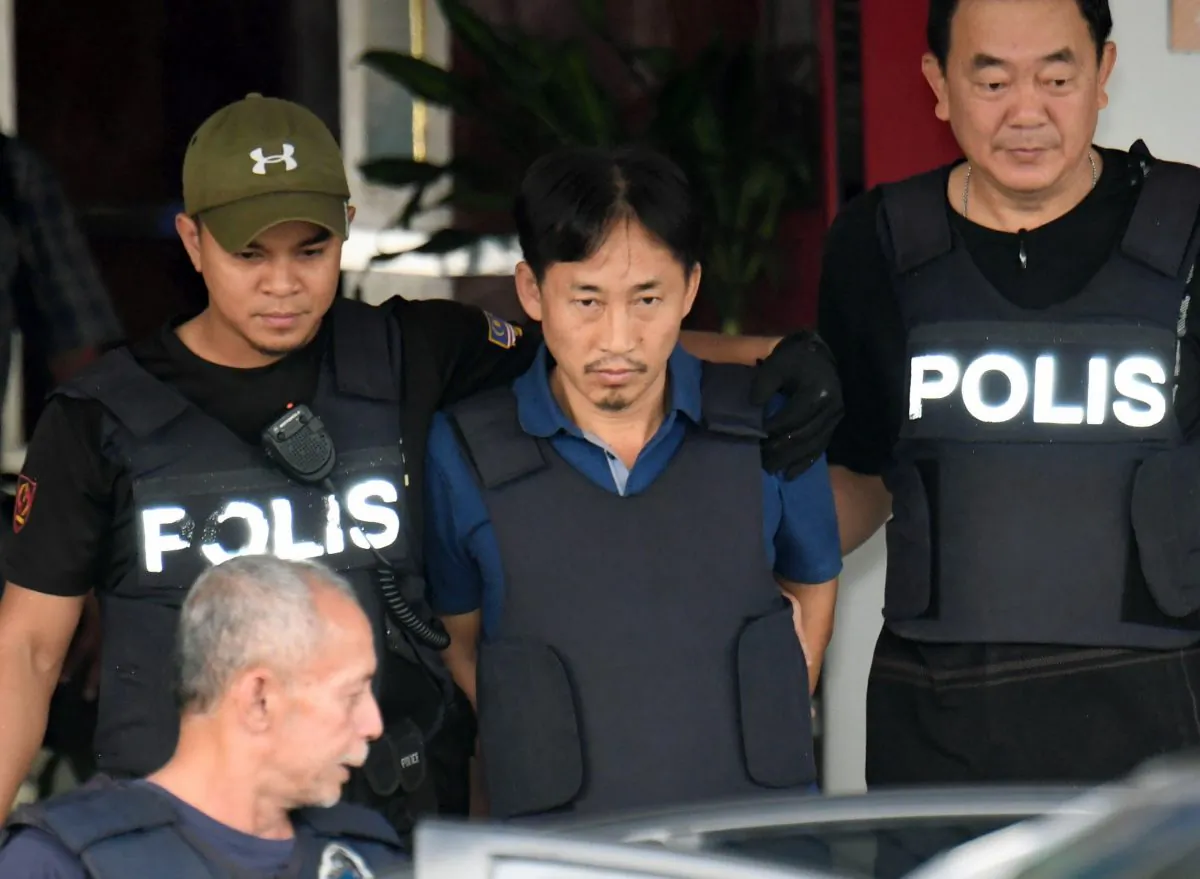 North Korean Ri Jong Chol, center, who was arrested in connection with the death of Kim Jong Un's half-brother, is transferred from Sepang district police station in Sepang, Malaysia on March 3, 2017. (Muneyoshi Someya/Kyodo News via AP)