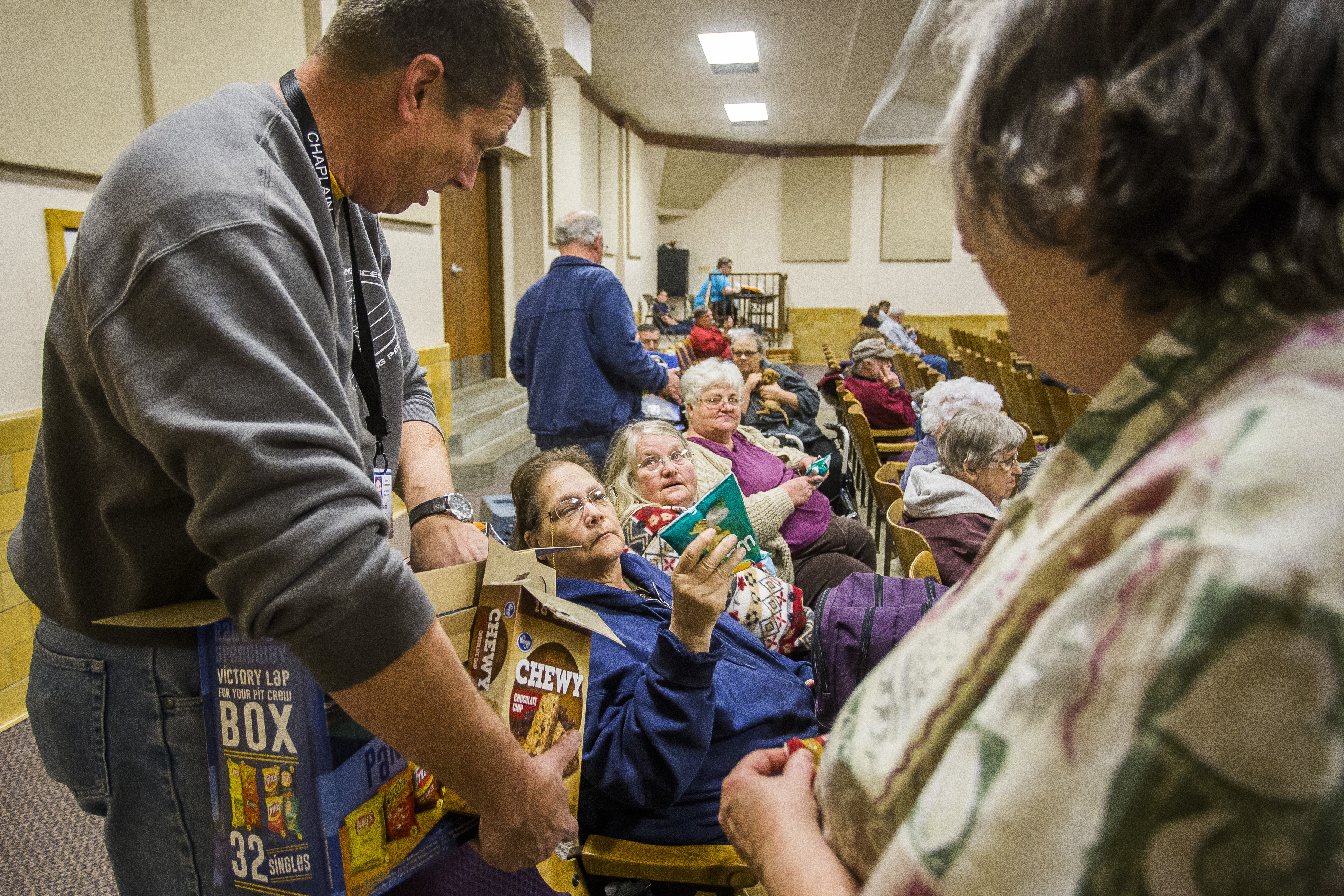 Southern Baptist Disaster Relief Chaplain Jeff Thompson passes bags of chips to (L-R) Suzanne Morgan, Carol Shaylor and Linda Nimmo inside an evacuation center at the Kansas State Fairgounds as a grassfire continues to rage north of Hutchinson, Kan., on March 6, 2017. (Katy Kildee/The Hutchinson News via AP)