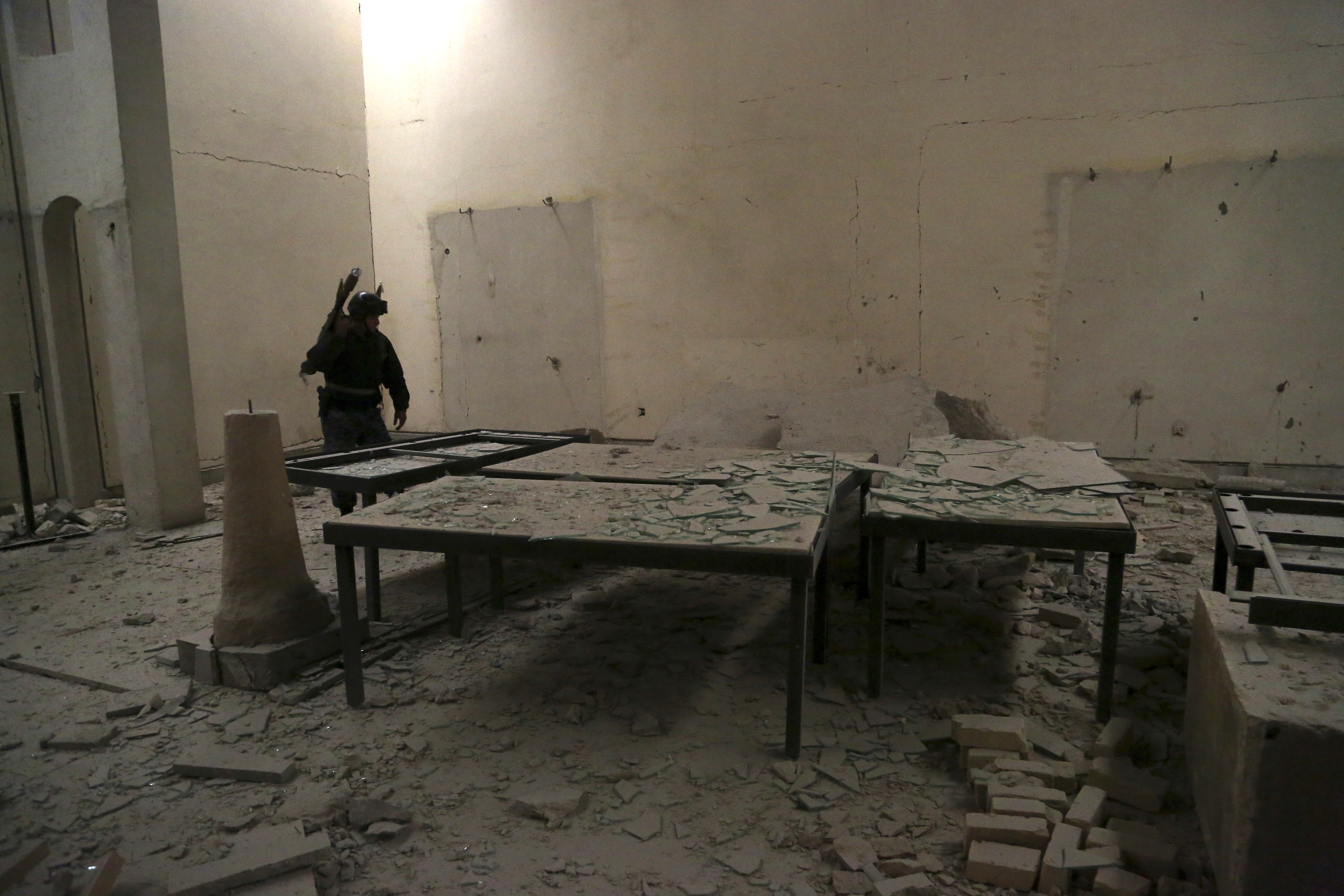 An Iraqi federal policeman inspects the inside of Mosul's heavily damaged museum. (AP Photo/Khalid Mohammed)