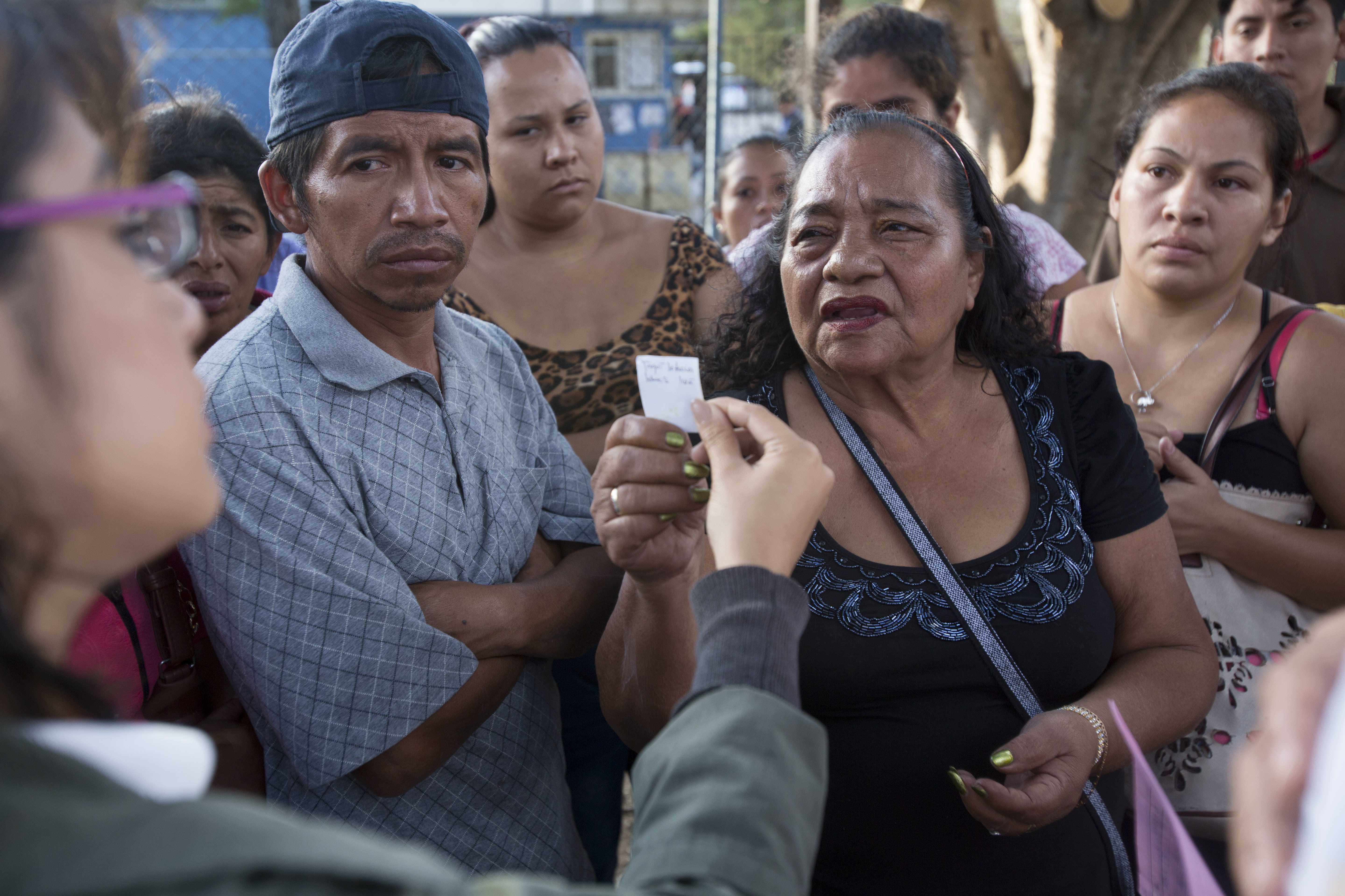 A woman tries to identify a person in a photo, held by a doctor outside the Roosevelt hospital, where the person in the photo is being treated for injuries after a fire, in Guatemala City on March 8, 2017. (AP Photo/Moises Castillo)