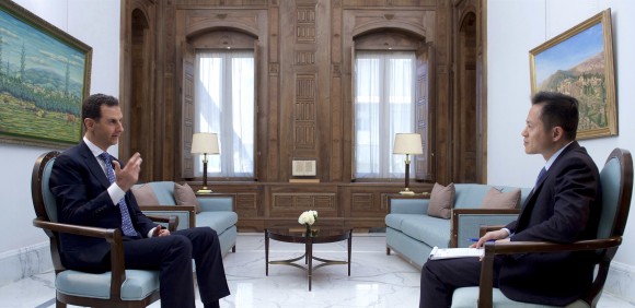 In this photo released by the Syrian official news agency SANA, Syrian President Bashar Assad, left, speaks during an interview with Hong-Kong based Phoenix TV in Damascus, Syria, Saturday, March 11, 2017. Assad said that his military's priority is to reach Islamic State's de-facto capital Raqqa, where U.S.-backed Kurdish-led forces are advancing. (SANA via AP)