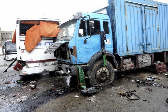 This photo released by the Syrian official news agency SANA shows blood soaked streets and several damaged buses in a parking lot at the site of an attack by twin explosions in Damascus, Syria, Saturday, March 11, 2017. Twin explosions Saturday near religious shrines frequented by Shiite pilgrims in the Syrian capital Damascus killed dozens of people, Arab media and activists report. (SANA via AP)