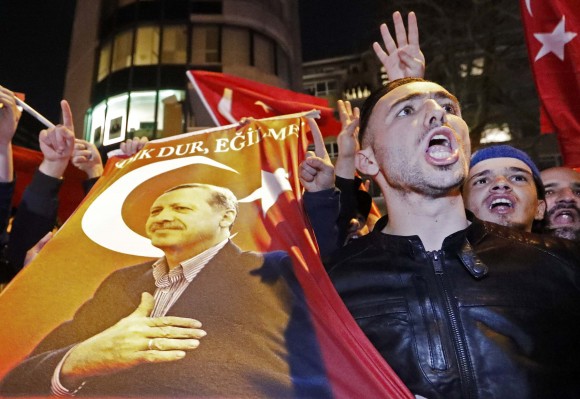 Demonstrators with banners of Turkish President Recep Tayyip Erdogan gather outsidethe Turkish consulate to welcome the Turkish Family Minister Fatma Betul Sayan Kaya, who decided to travel to Rotterdam by land after Turkish Foreign Minister Mevlut Cavusoglu's flight was barred from landing by the Dutch government, in Rotterdam, Netherlands March 11, 2017. (REUTERS/Yves Herman TPX IMAGES OF THE DAY)
