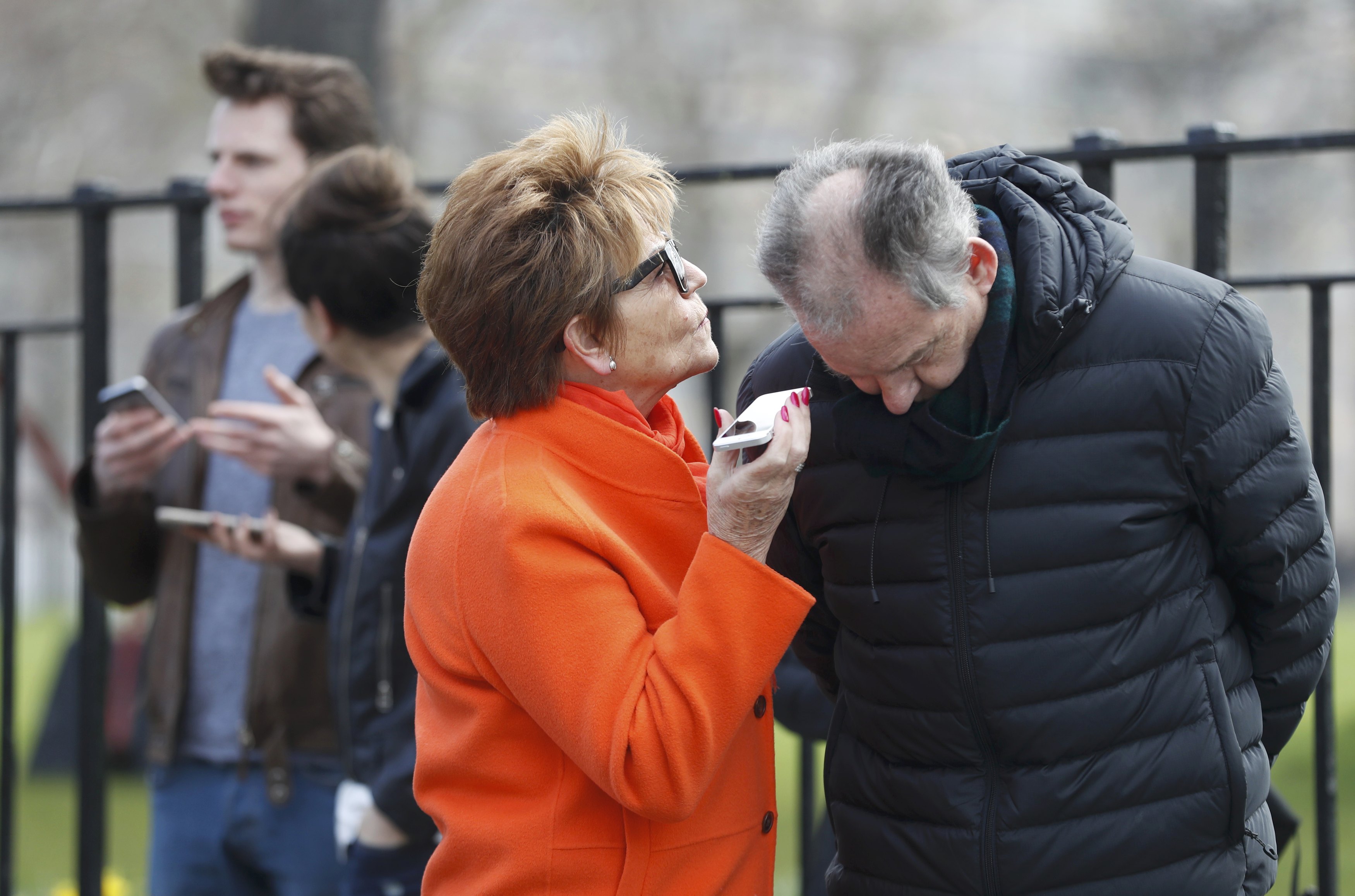 People listen and watch on their mobile devices as Scotland's First Minister Nicola Sturgeon demands a new independence referendum to be held in late 2018 or early 2019, once the terms of Britain's exit from the European Union have become clearer, outside Bute House, in Edinburgh, Scotland, Britain on March 13, 2017. (REUTERS/Russell Cheyne)