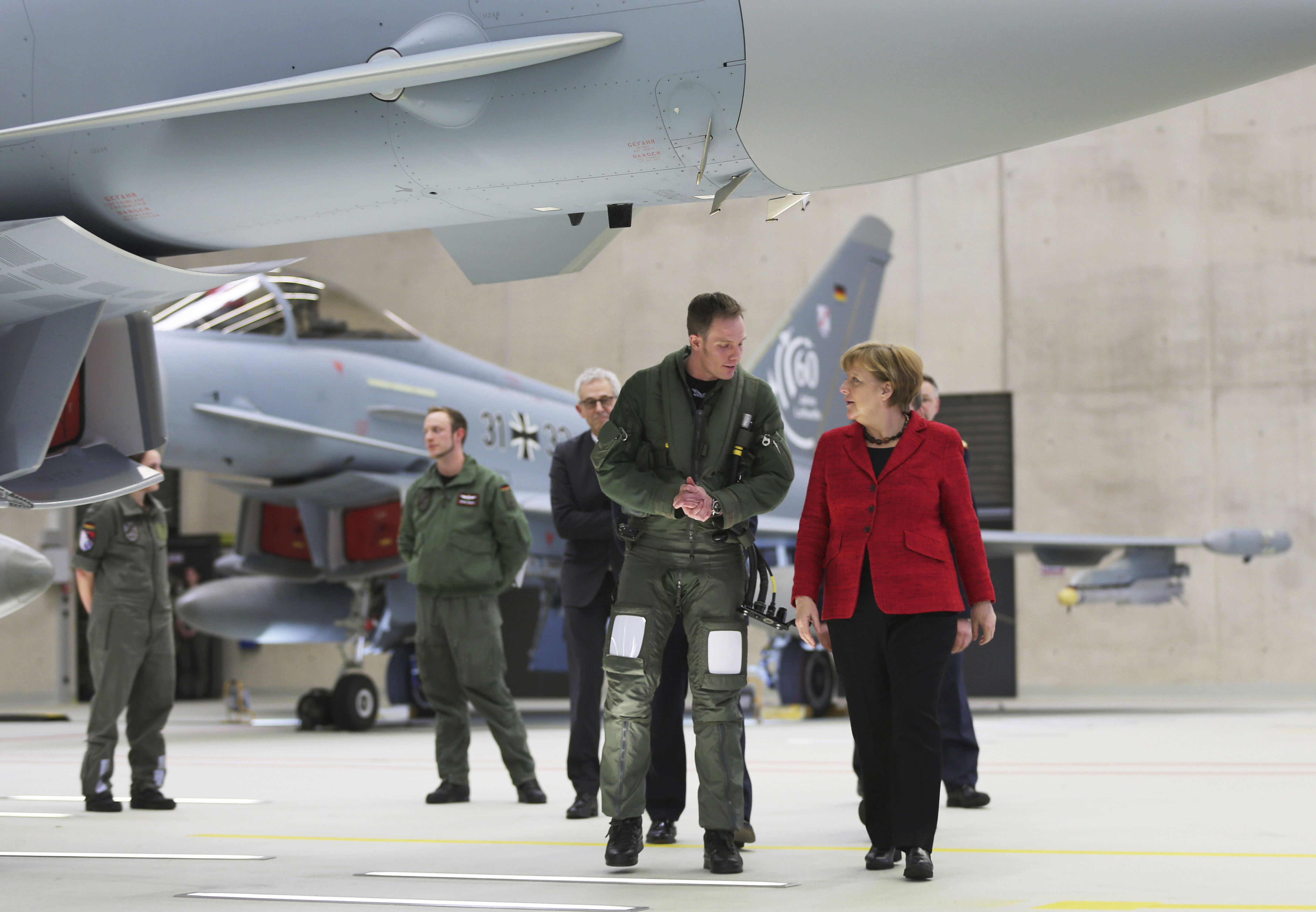 German Chancellor Angela Merkel speaks to pilot Patrick Betling (C) next to a Eurofighter in Noervenich, Germany on 21, 2016. (Oliver Berg//dpa via AP)
