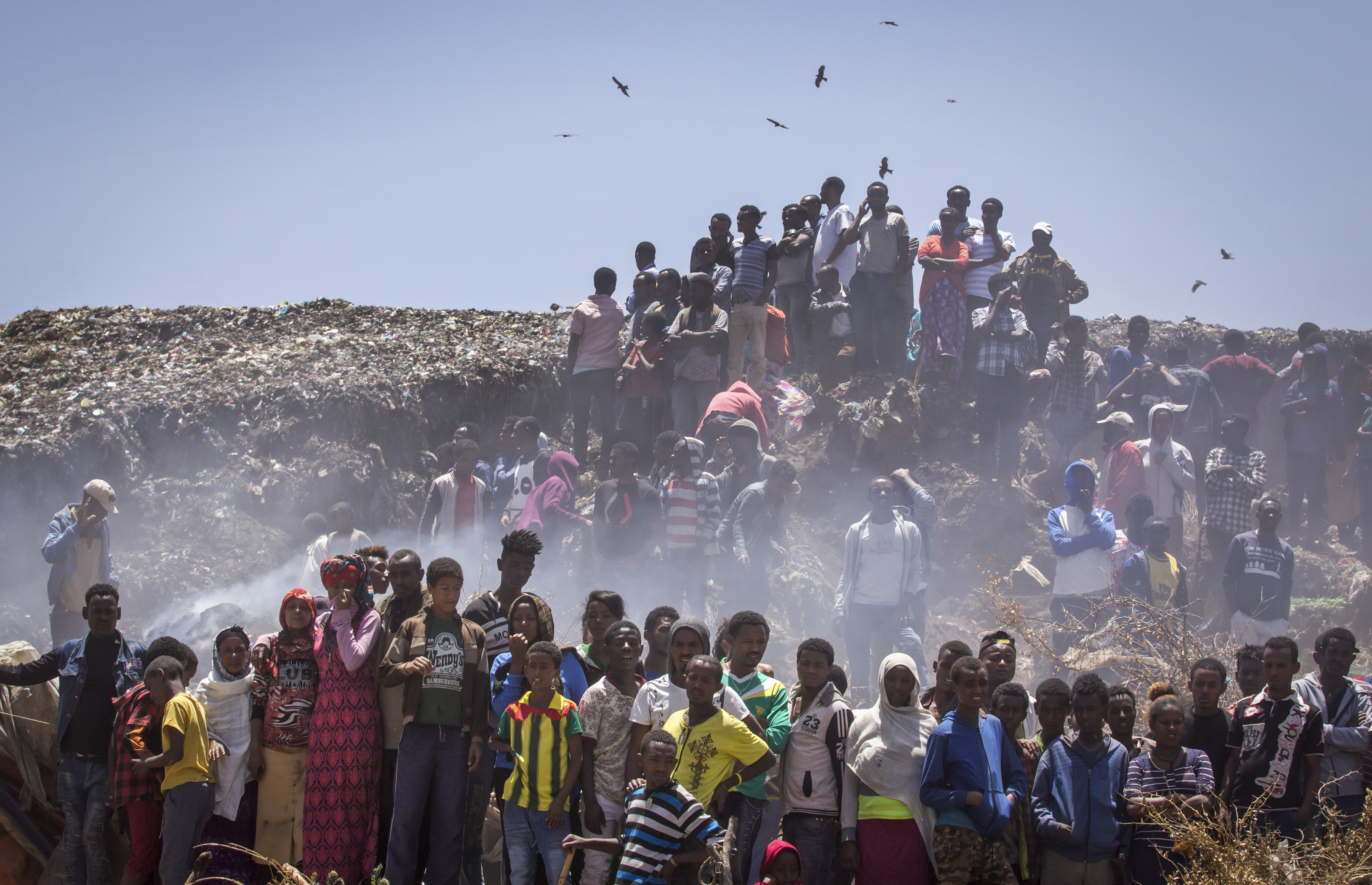 Residents look on as rescue efforts take place at the scene of a garbage landslide, on the outskirts of the capital Addis Ababa, in Ethiopia on March 12, 2017. (AP Photo/Mulugeta Ayene)