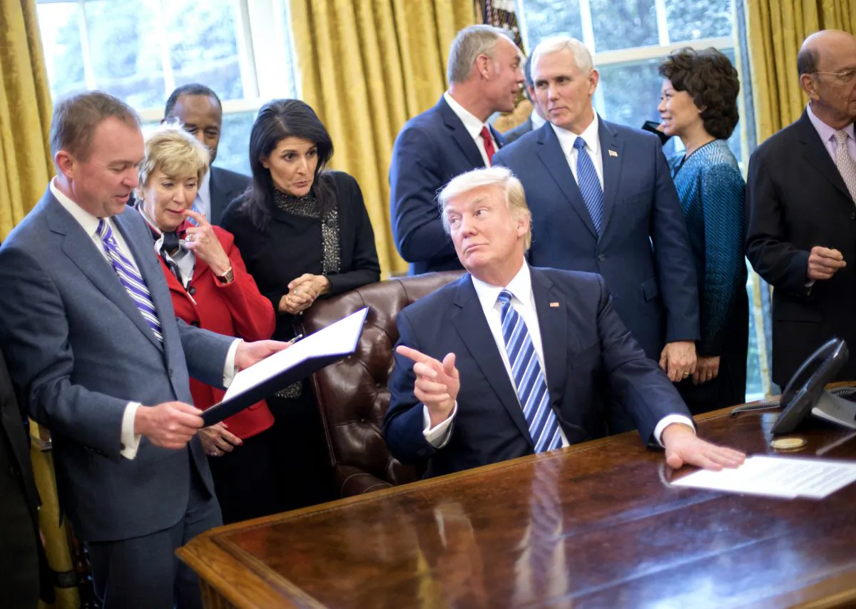 President Donald Trump looks over towards Budget Director Mick Mulvaney (L) after signing an executive order in the Oval Office of the White House in Washington on March 13, 2017. (AP Photo/Pablo Martinez Monsivais)