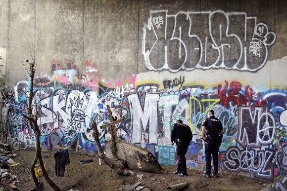 Police Sgt. Mike Braley, left, and officer Kevin Davis walk along the bottom of a highway overpass, a known location for drug use, to check for anyone living there in Everett, Wash. on Feb. 16, 2017. (AP Photo/Elaine Thompson)