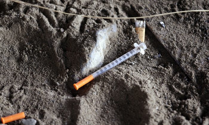 A discarded syringe sits in the dirt with other debris under a highway overpass where drug users are known to congregate in Everett, Wash., on Feb. 16, 2017. (Elaine Thompson/AP Photo)