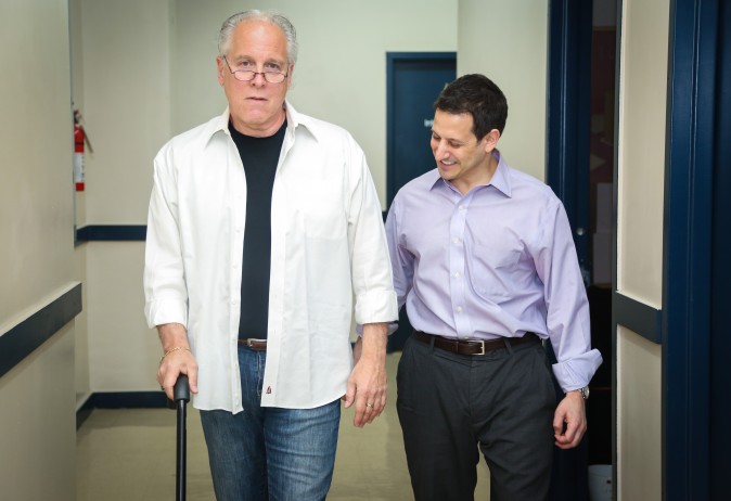 Alex Greenspan (R) MSPT, assists a patient in walking in New York. (Benjamin Chasteen/Epoch Times)