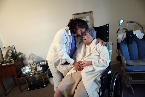 Hhome health aide Wendy Cerrato hugs Olga Socarras as she helps her during a visit in Miami in this file photo. (Joe Raedle/Getty Images)