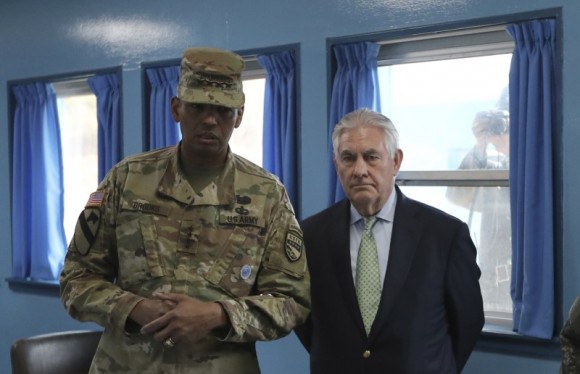Secretary of State Rex Tillerson is briefed by U.S. Gen. Vincent K. Brooks, commander of the United Nations Command, Combined Forces Command and United States Forces Korea, as a North Korean soldier takes a photograph through a window at the border village of Panmunjom, which has separated the two Koreas since the Korean War. (REUTERS/Lee Jin-man/Pool)