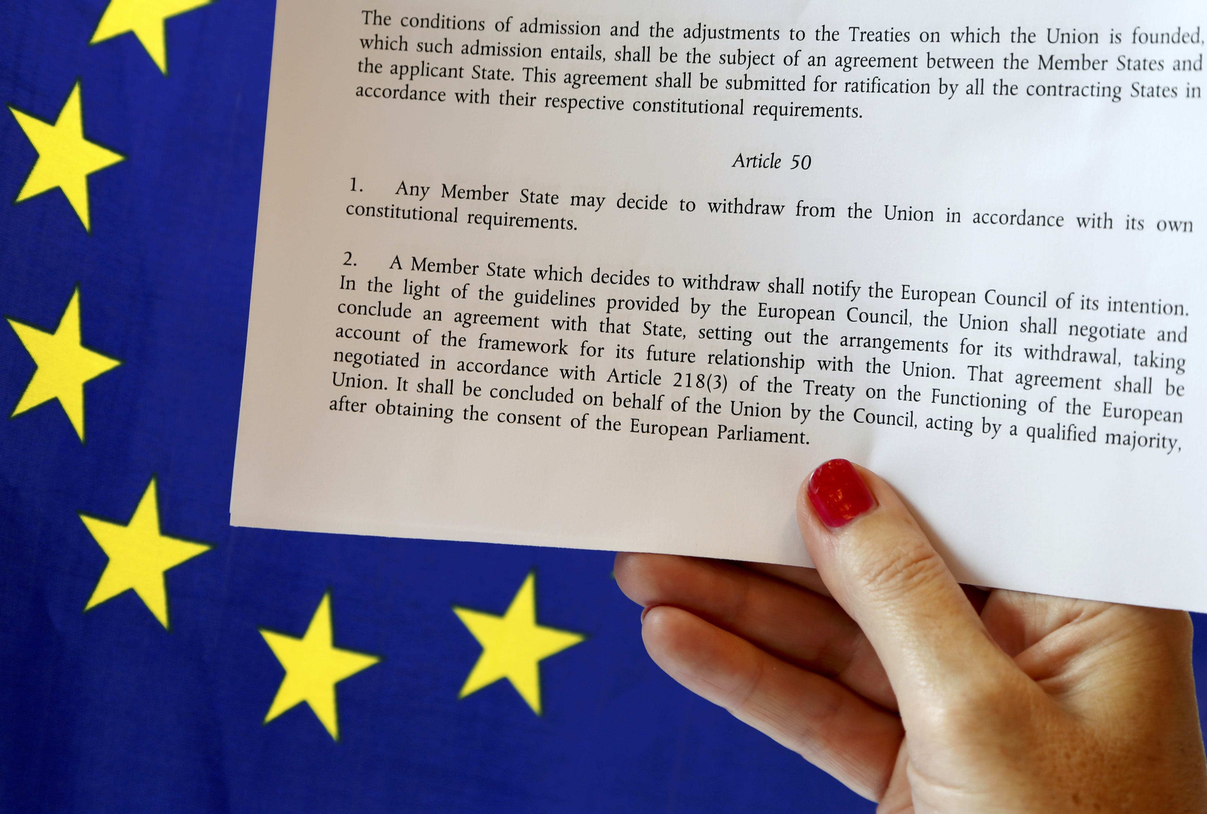 Article 50 of the EU's Lisbon Treaty that deals with the mechanism for departure is pictured near an EU flag following Britain's referendum results to leave the European Union, in this photo illustration taken in Brussels, Belgium on June 24, 2016. (REUTERS/Francois Lenoir/Illustration)
