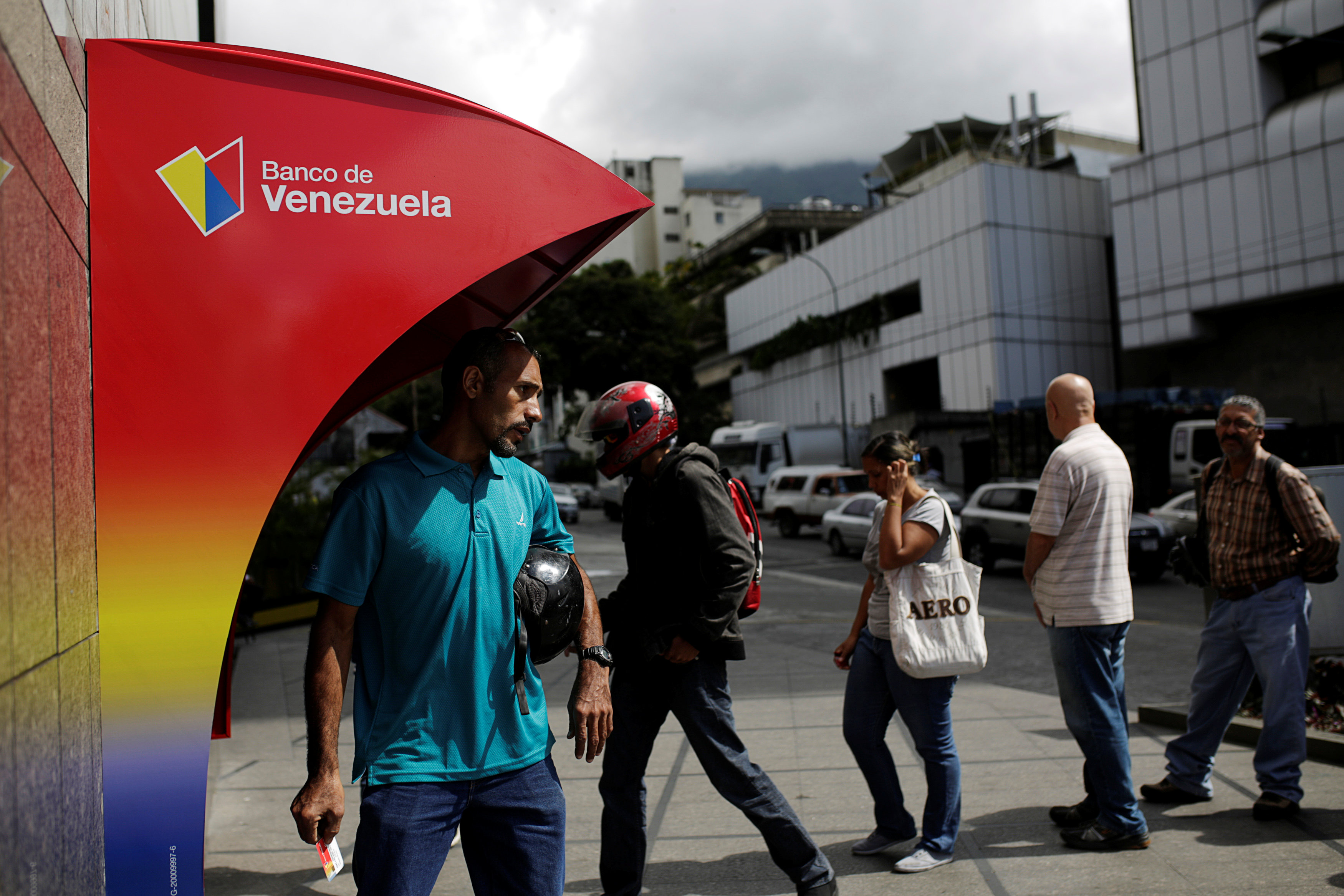 People line up to withdraw cash from an automated teller machine (ATM) outside a Banco de Venezuela branch in Caracas, Venezuela on March 14, 2017. (REUTERS/Marco Bello)
